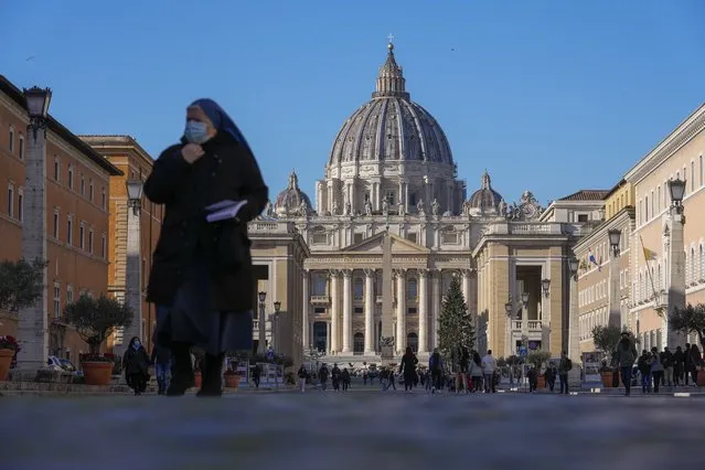 A nun walks past St. Peter's Square and Basilica, at the Vatican, Friday, December 17, 2021. Pope Francis is celebrating his 85th birthday Friday, a milestone made even more remarkable given the coronavirus pandemic, his summertime intestinal surgery and the weight of history: His predecessor retired at this age and the last pope to have lived any longer was Leo XIII over a century ago. (Photo by Andrew Medichini/AP Photo)