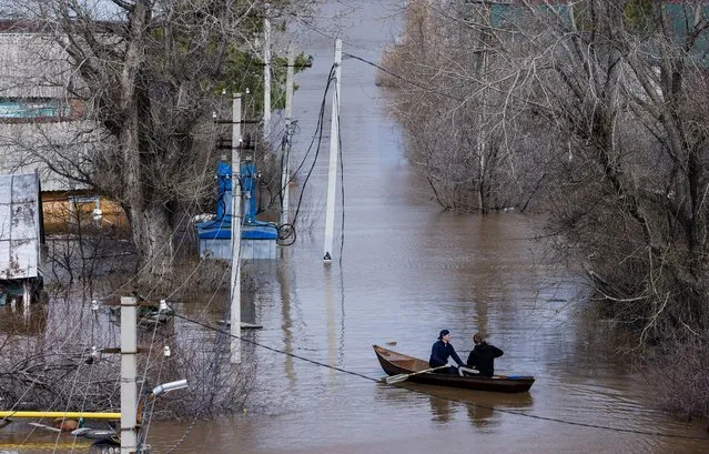 People row a boat through a flooded residential area in Orenburg, Russia, on April 12, 2024. (Photo by Maxim Shemetov/Reuters)
