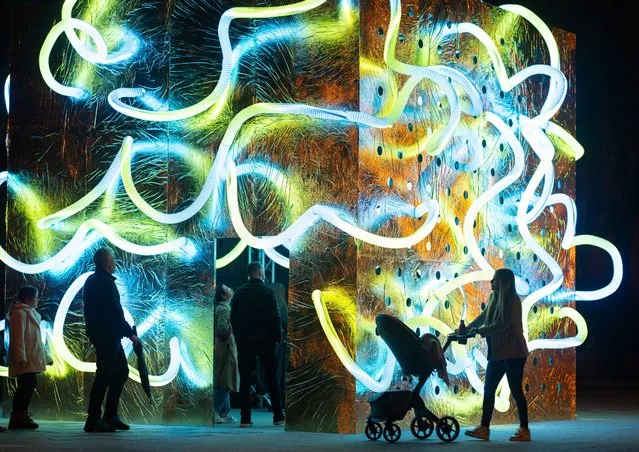 People walk next to a light installation during the Festival of Lights in Zagreb, Croatia, on March 21, 2024. (Photo by Antonio Bronic/Reuters)