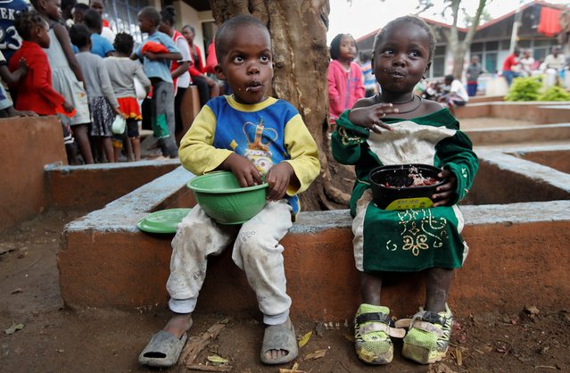 Displaced children eat after getting food rations at a rescue centre after the Nairobi river burst its banks and destroyed their homes within the Mathare valley settlement in Nairobi, Kenya on April 30, 2024. (Photo by Monicah Mwangi/Reuters)