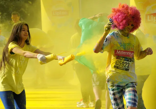 A runner gets a splash of colored powder during the Color Run, a 5km paint race that celebrates healthiness, happiness and individuality, in Warsaw, Poland, Saturday, June 27, 2015. (Photo by Alik Keplicz/AP Photo)