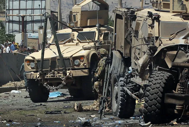 Armored vehicles remain at the site of a blast targeting the NATO convoy in Kabul, Afghanistan, Tuesday, June 30, 2015. (Photo by Massoud Hossaini/AP Photo)
