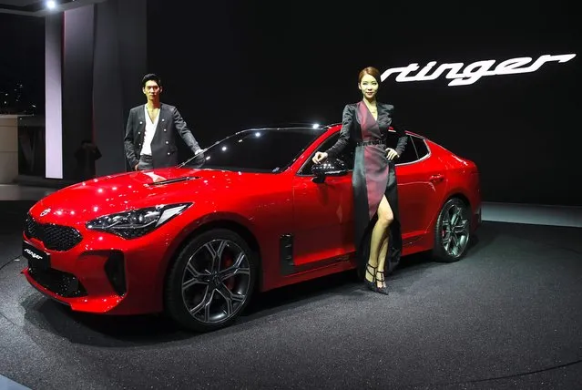South Korean models pose with Kia Mortors Stinger during a press preview of the Seoul Motor Show in Goyang, northwest of Seoul, on March 30, 2017. (Photo by Jung Yeon-Je/AFP Photo)