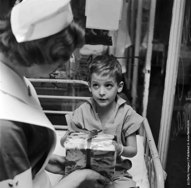 1955: A young patient in the pediatric ward of the Lenox Hill Hospital, America receives an unexpected Christmas present from student nurse Linda Gross