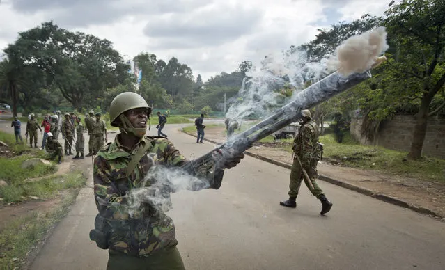 A riot policeman fires tear gas towards opposition supporters during a protest in downtown Nairobi, Kenya Monday, May 9, 2016. (Photo by Ben Curtis/AP Photo)