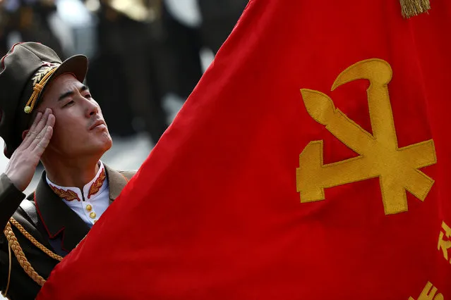 A soldier salutes a Workers’ party flag during a military parade marking the 105th birth anniversary of country's founding father Kim Il Sung in Pyongyang, North Korea, April 15, 2017. (Photo by Damir Sagolj/Reuters)