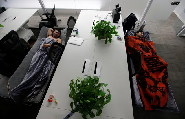 Han Liqun (L), HR manager of RenRen Credit Management Co., and IT engineer Xiang Siyang sleep on camp beds at the office after finishing work early morning, in Beijing, China, April 27, 2016. (Photo by Jason Lee/Reuters)