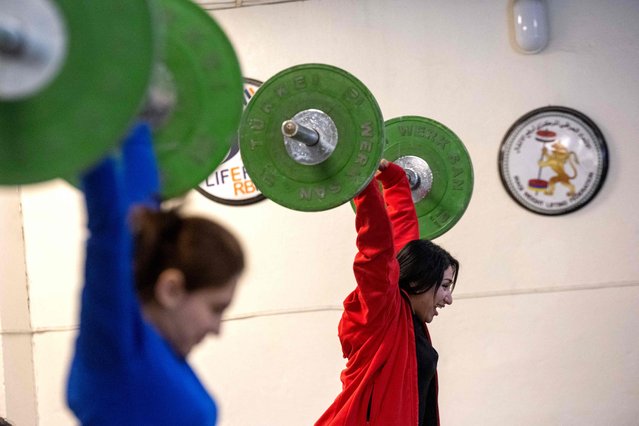Iraqi Kurdish women train weight lifting at a centre in Iraq's Kurdish regional capital of Arbil on February 2, 2022. Women's sports have developed at a sluggish pace across much of conservative Iraq, which has struggled through decades of conflict. But the Kurdistan region was spared the brunt of the violence and destruction, and its infrastructure, facilities and government funding have paved the way for a boom in professional women's sports. (Photo by AFP Photo/Stringer)