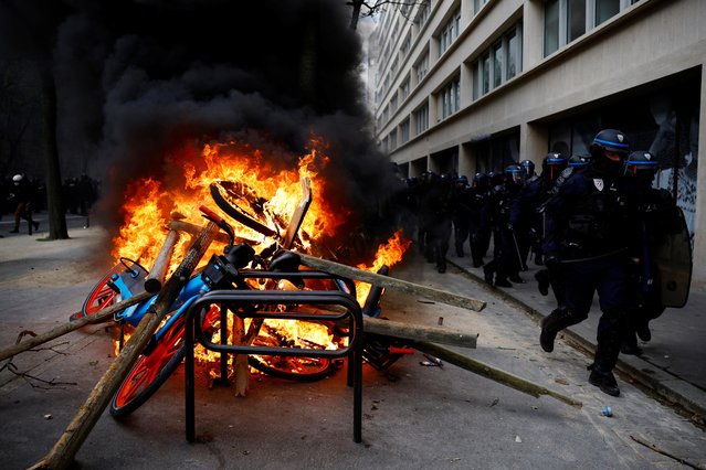 French CRS riot police run past objects on fire amid clashes with protesters at a demonstration as part of the eleventh day of nationwide strikes and protests against French government's pension reform, in Paris, France on April 6, 2023. (Photo by Sarah Meyssonnier/Reuters)