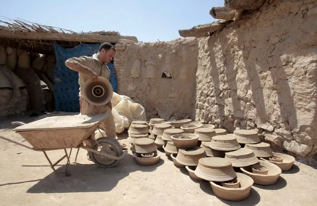 Iraqi potters work on a clay pots at a workshop in Najaf, south of Baghdad, July 23, 2015. (Photo by Alaa Al-Marjani/Reuters)