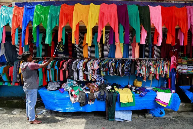 A vendor arranges clothes at his roadside shop in Kochi, India, May 18, 2017. (Photo by Sivaram V/Reuters)