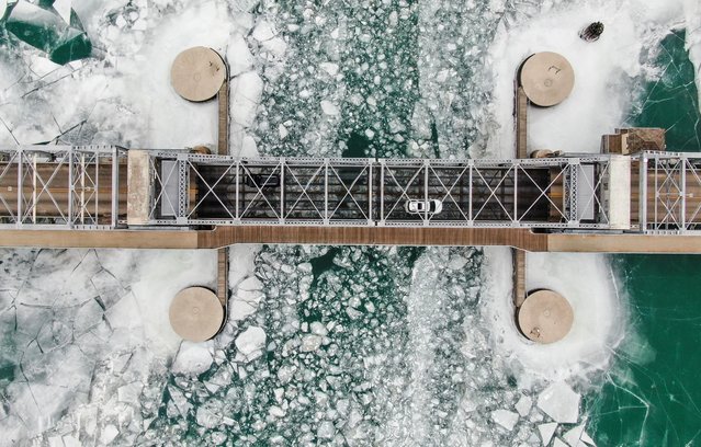 An aerial photo made with a drone shows ice formations under the Michigan Street Bridge in Sturgeon Bay, Wisconsin, 02 February 2022. According to The Great Lakes Integrates Science and Assessments team, the US Great Lakes waters are warming at a greater rate than regional atmospheric temperatures and the loss of winter ice is a major factor. Profound impacts from the loss of ice cover a range from increased severity of lake-effect precipitation, lake stratification, plankton production, and fish egg protection, among others. (Photo by Tannen Maury/EPA/EFE)