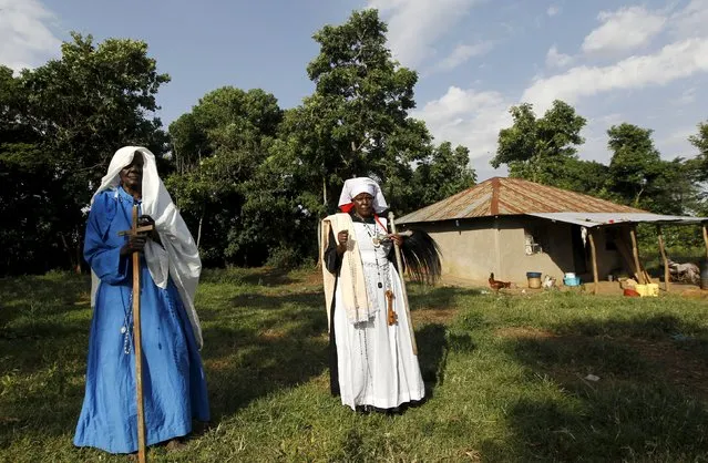 Clementina Auma Ojwang (L) and her daughter Margaret Ngesa (R) of the Legion Maria of African Church Mission pose for a photograph after praying for the State visit by U.S. President Barack Obama inside their family sacred hut in Kogelo, west of Kenya's capital Nairobi, July 15, 2015. Ngesa said, “We are proud of better roads, improved security and business opportunities since Barack Obama became the U.S. President”. (Photo by Thomas Mukoya/Reuters)