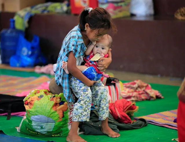 A girl carries a baby while waiting for relief goods inside of the evacuation centre in Baloi, Lanao Del Norte, Philippines May 28, 2017. (Photo by Romeo Ranoco/Reuters)