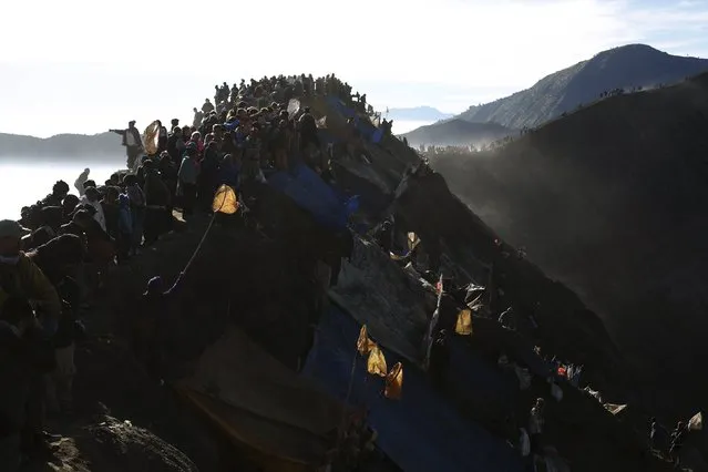 People stand on top of the crater of Mount Bromo to attend the Kasada Festival in Probolinggo, Indonesia's East Java province, August 1, 2015. (Photo by Reuters/Beawiharta)