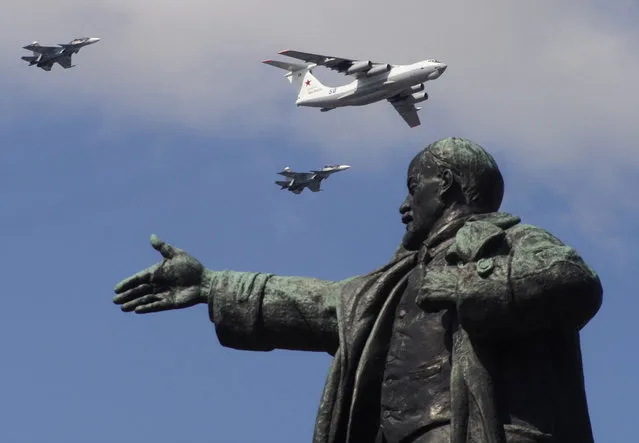 Military planes fly above a statue of Soviet Union founder Vladimir Lenin during a Naval parade rehearsal in St. Petersburg, Russia, Thursday, July 25, 2019. The celebration of Navy Day in Russia is traditionally marked on the last Sunday of July and will be celebrated on July 28 this year. (Photo by Dmitri Lovetsky/AP Photo)