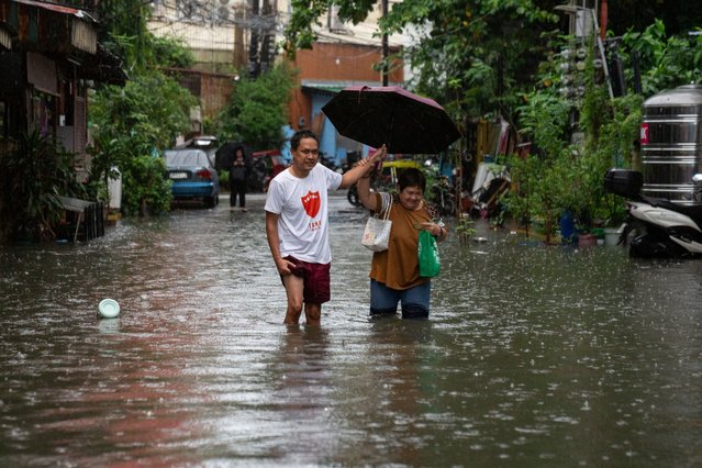 People wade through a flooded street amid heavy rains brought by Typhoon Gaemi, in Manila, Philippines, on July 24, 2024. (Photo by Lisa Marie David/Reuters)