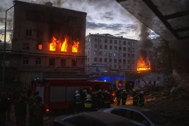 Emergency services work at the site where fires were triggered by an explosion in Kyiv, Ukraine, Thursday, April 28, 2022. Russia struck the Ukrainian capital of Kyiv shortly after a meeting between President Volodymyr Zelenskyy and U.N. Secretary-General António Guterres on Thursday evening. (Photo by Emilio Morenatti/AP Photo)
