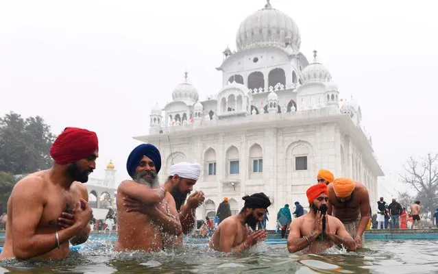 Sikh devotees take a dip in the holy sarovar (water tank) during Basant Panchami celebrations at the Sikh Shrine Gurudwara Chheharta Sahib on the outskirts of Amritsar on January 29, 2020. (Photo by Narinder Nanu/AFP Photo)