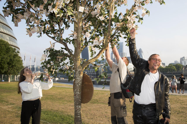 Londoners walking through Potters Field Park were surprised to see a “money tree” blooming with £9820 in £10 notes, the average amount a working British family has in savings, on July 24, 2014 in London, England. The tree was planted by Sunlife to encourage the nation to start saving at least £10 a month for a brighter future. (Photo by Tristan Fewings/Getty Images for SunLife)