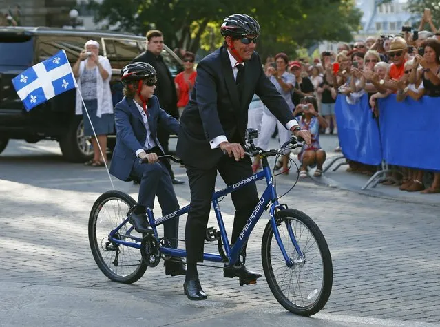 Parti Quebecois leader Pierre Karl Peladeau rides a tandem bike with his son Thomas as he arrives to his wedding at the Musee de l'Amerique Francophone in Quebec City, August 15, 2015. (Photo by Mathieu Belanger/Reuters)