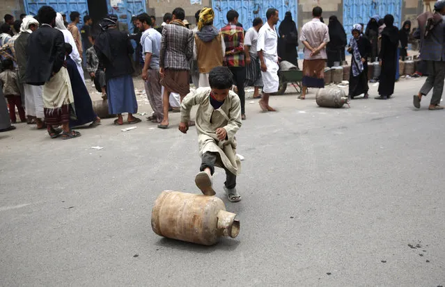 A Yemeni boy rolls a canister of gas he bought, after waiting for hours in Sanaa, Yemen, Tuesday, August 18, 2015. The Saudi-imposed blockade has created severe shortages of gas, petrol, and other goods, causing prices to skyrocket. (Photo by Hani Mohammed/AP Photo)