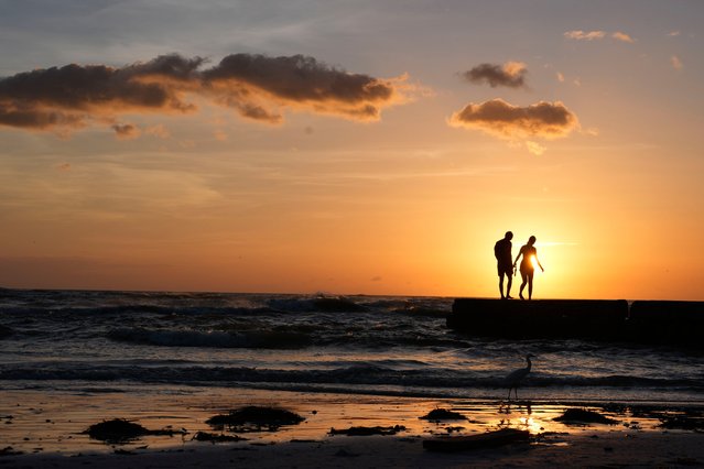 People from Sarasota, Fla., visit a familiar beach on Siesta Key, Fla., which they say was already decimated by Hurricane Helene, and lost feet more of sand coverage in Hurricane Milton, Thursday, October 10, 2024. (Photo by Rebecca Blackwell/AP Photo)