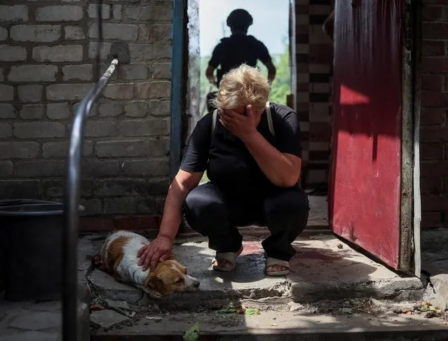 Lena, 58, reacts near her critically wounded during a Russian military strike, dog Hera, as Russia's attack on Ukraine continues, in Kostiantynivka, Ukraine on July 9, 2022. (Photo by Gleb Garanich/Reuters)