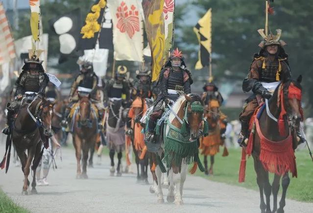 Local people in samurai armor ride their horses during a parade at the annual Soma Nomaoi Festival in Minamisoma, Fukushima Prefecture, on July 29, 2012. Some 400 horses and thousands of people took part in the 1,000-year-old “Soma Nomaoi”, or wild horse chase, at the weekend in the shadow of Japan's crippled Fukushima nuclear plant. (Photo by Toru Yamanaka/AFP Photo)
