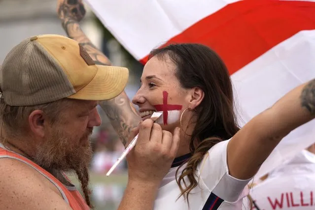 A supporter has the England flag painted on her face in the fan zone in Trafalgar Square as fans gather to watch on a big screen the final of the Women's Euro 2022 soccer match between England and Germany being played at Wembley stadium in London, Sunday, July 31, 2022. (Photo by Frank Augstein/AP Photo)