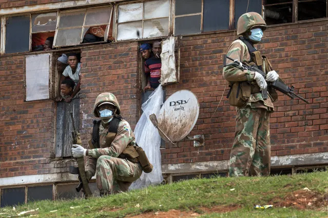 South African National Defense Forces patrol the Men's Hostel in the densely populated Alexandra township east of Johannesburg, Saturday, March 28, 2020, enforcing a strict lockdown in an effort to control the spread of the coronavirus. (Photo by Jerome Delay/AP Photo)