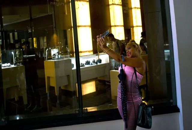 A Cuban girl takes a selfie in front of a window of a luxury store at the Manzana de Gomez Kempinski five-star hotel in Havana, Cuba, Monday, May 8, 2017. With other sectors declining, Cuba’s increasingly important tourism industry is under pressure to change its state-run hotels’ reputation for charging exorbitant prices for rooms and food far below international standards. The Manzana de Gomez Kempinski bills itself as Cuba’s first real five-star hotel, and the brand-name shops around it appear designed to reinforce that. (Photo by Ramon Espinosa/AP Photo)