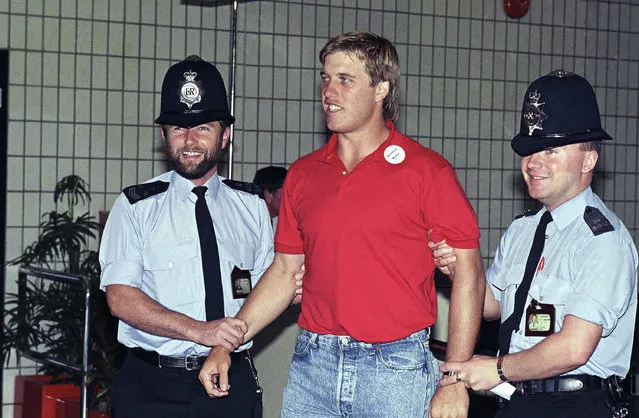 Denver Broncos quarterback John Elway jokes with two British policemen upon his team's arrival outside Gatwick Airport on Monday, August 3, 1987 in London. The Broncos are in town to meet the Los Angeles Rams in an exhibition football game at London?s Wembley Stadium on August 9. (Photo by Dave Gaywood/AP Photo)