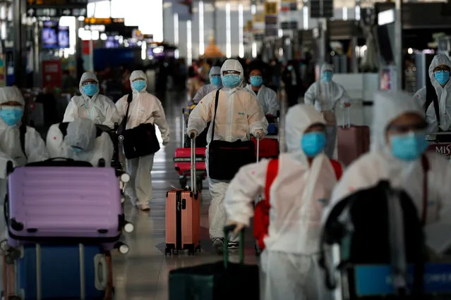 Chinese students living in Thailand wear protective suits as a measure of protection against the coronavirus disease (COVID-19) as they walk at the Suvarnabhumi Airport before boarding a repatriation flight, in Bangkok, Thailand on April 21, 2020. (Photo by Jorge Silva/Reuters)