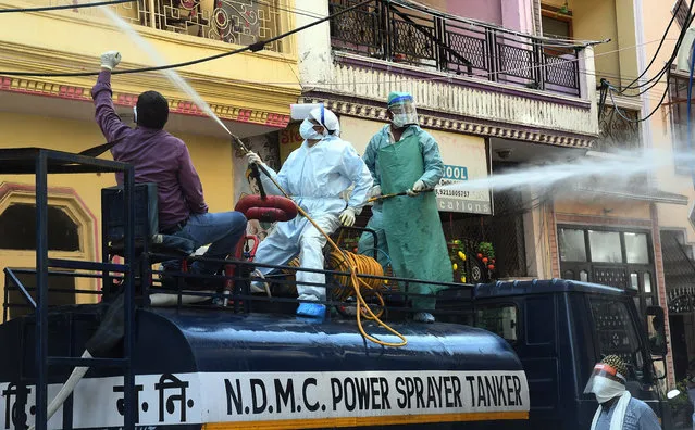 Municipal workers spray disinfectant in a residential area of North Delhi, India, 22 April 2020 (issued on 23 April 2020). A sanitization drive was held on 22 April, in a bid to quell the spread of the SARS-CoV-2 coronavirus, which causes the Covid-19 disease. India's Prime Minister Narendra Modi announced on 14 April that the country's initial 21-day lock down will be extended until 03 May. (Photo by EPA/EFE/Stringer)