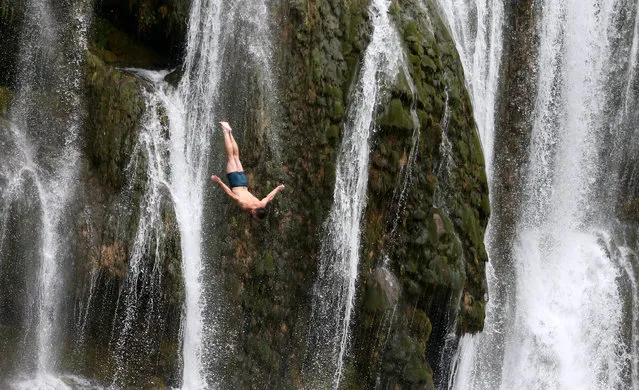A competitor takes part in the annual international waterfall jumping competition held in the old town of Jajce, Bosnia and Herzegovina on August 13, 2022. (Photo by Dado Ruvic/Reuters)