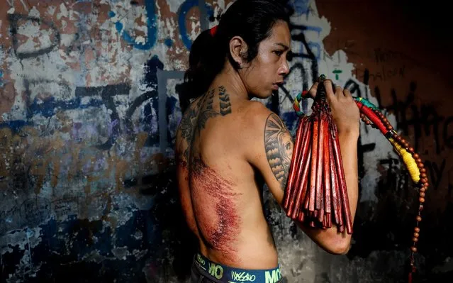 Filipino Catholic Richard Pineda, 30, stands for a portrait showing his bloodied back and bamboo whip shortly after finishing the ritual of self-flagellation on Maundy Thursday, amid the enforcement of home quarantine to contain the coronavirus disease (COVID-19), in Manila, Philippines, April 9, 2020. (Photo by Eloisa Lopez/Reuters)