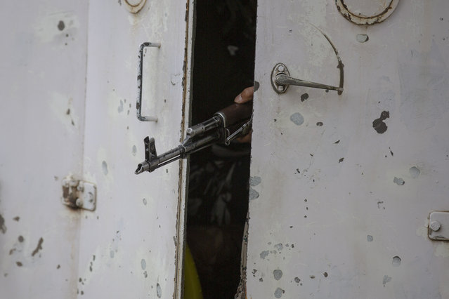Barrel of a gun belonging to an Indian paramilitary soldier is seen between partially closed doors of an armored vehicle as they drive towards the site of an operation in Awantipora area, south of Srinagar, Indian controlled Kashmir, Wednesday, May 6, 2020. Government forces killed a top rebel commander and his aide in Indian-controlled Kashmir on Wednesday and shut down cellphone and mobile internet services during subsequent anti-India protests, officials, and residents said. (Photo by Dar Yasin/AP Photo)