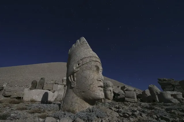 Ancient statues are seen as stargazers gather to watch the Perseid meteor shower atop Mount Nemrut in southeastern Turkey, Saturday, August 13, 2022. Hundreds spent the night at the UNESCO World Heritage Site for the annual meteor show that stretches along the orbit of the comet Swift–Tuttle. Perched at an altitude of 2,150 meters (over 7,000 feet), the statues are part of a temple and tomb complex that King Antiochus I, of the ancient Commagene kingdom, built as a monument to himself. (Photo by Emrah Gurel/AP Photo)