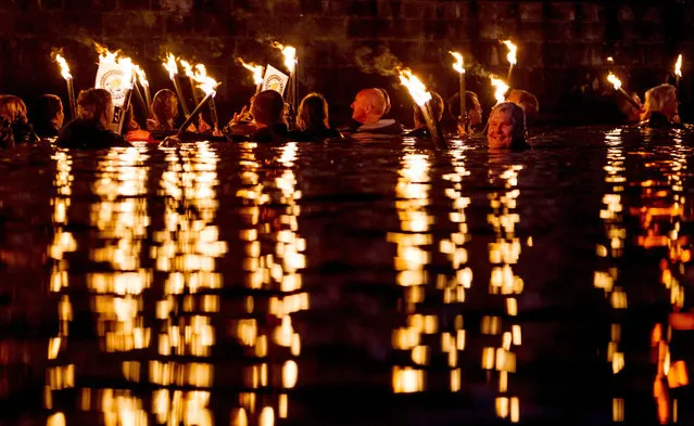 An image made available on 07 August 2016 shows torch swimmers floating along the Maschsee lake in Hannover, Germany, 06 August 2016. About 130 swimmers took part in the traditional torchlight swim that is an integral part of the program for the Maschsee festival. (Photo by Peter Steffen/EPA)