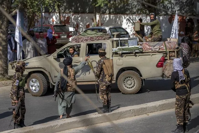 Taliban fighters stand guard at the explosion site, near a mosque, in Kabul, Afghanistan, Friday, September 23, 2022. (Photo by Ebrahim Noroozi/AP Photo)