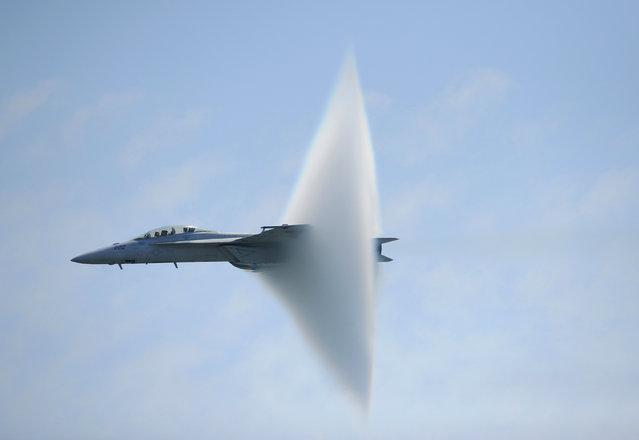 A ring of water vapor is created as pilots Lt. Justin Halligan (L) and Lt. Michael Witt (R) fly their F/A-18F Super Hornet airplane within 200mph of breaking the sound barrier while performing at New York Air Show at Jones Beach in Wantagh, New York, May 23, 2009. (Photo by Christopher Pasatieri/Reuters)