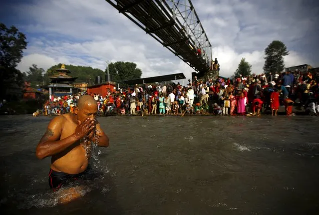 A Hindu devotee performs a ritual on Bagmati River during Kuse Aunse (Father's Day) at Gokarna Temple in Kathmandu, Nepal September 13, 2015. (Photo by Navesh Chitrakar/Reuters)