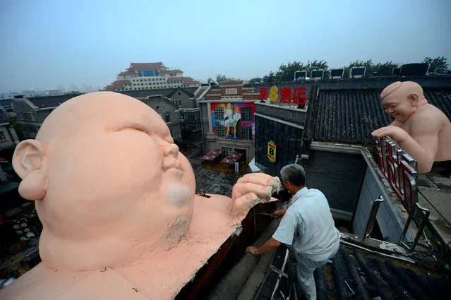 A man demolishes a statue in Jinan, Shandong Province, China, August 5, 2016. (Photo by Reuters/Stringer)