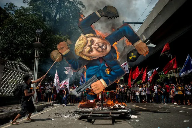 Protesters burn an image of US President Donald Trump fashioned on a swastika as they march the streets of Manila during the start of the ASEAN meetings between heads of state on November 13, 2017 in Manila, Philippines. (Photo by Jes Aznar/Getty Images)
