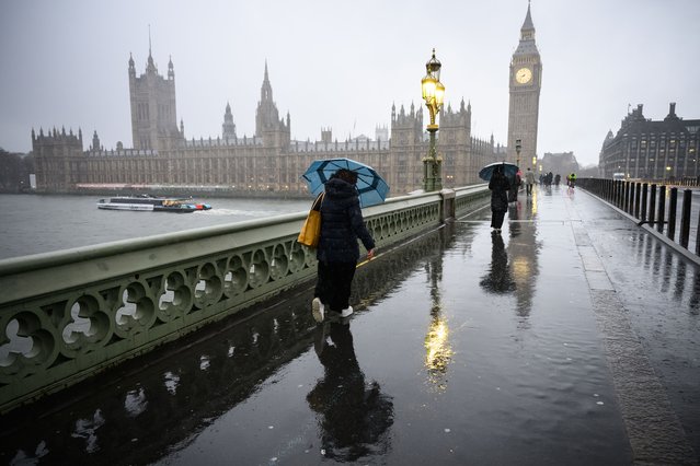 Commuters are battered by strong winds as they cross Westminster Bridge on January 24, 2025 in London, United Kingdom. The Met Office has issued rare red Warnings for wind for Northern Ireland as well as central and southwestern areas of Scotland. These are accompanied by wider Amber and Yellow Warnings for wind, as well as Yellow Warnings for rain and snow across the UK. (Photo by Leon Neal/Getty Images)