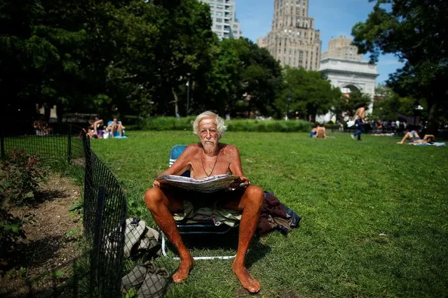 A man takes a sunbath helped with a light reflector during a warm and humid day in New York, U.S., July 19, 2020. (Photo by Eduardo Munoz/Reuters)