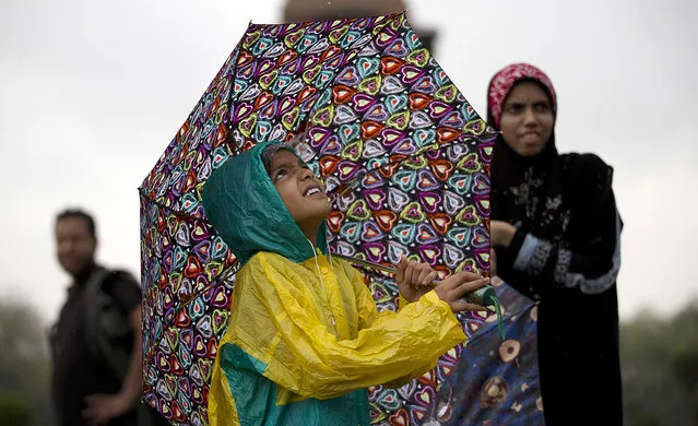 An Indian girl holds an umbrella and looks skywards as it rains in New Delhi, India, Thursday, September 1, 2016. Monsoon season in India begins in June and ends in October. (Photo by Tsering Topgyal/AP Photo)