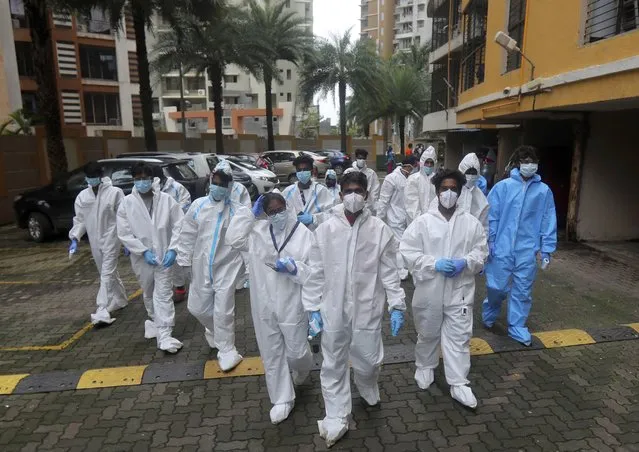 Health workers arrives to screen people for COVID-19 symptoms at a residential building in Mumbai, India, Sunday, July 26, 2020. India is the third hardest-hit country by the pandemic in the world after the United States and Brazil. (Photo by Rafiq Maqbool/AP Photo)