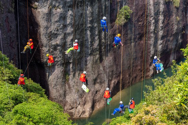 Volunteers descend the cliffs via safety ropes to clean garbage left by tourists on the cliffs on the Earth Day on April 22, 2025 in Taizhou, Zhejiang Province of China. (Photo by Xu Weijie/VCG via Getty Images)